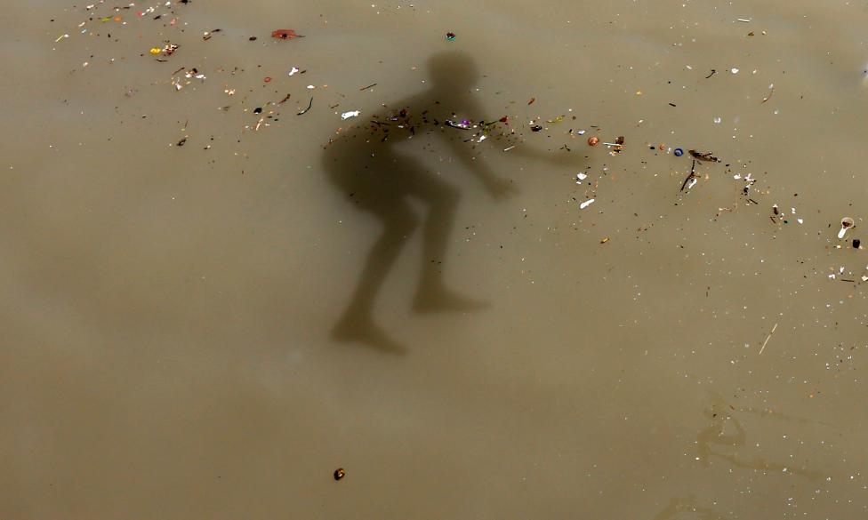 The shadow of a boy is seen as he jumps into the Ganges river to cool off on a hot summer day on the outskirts of Kolkata, April 22, 2016. REUTERS/Rupak De Chowdhuri