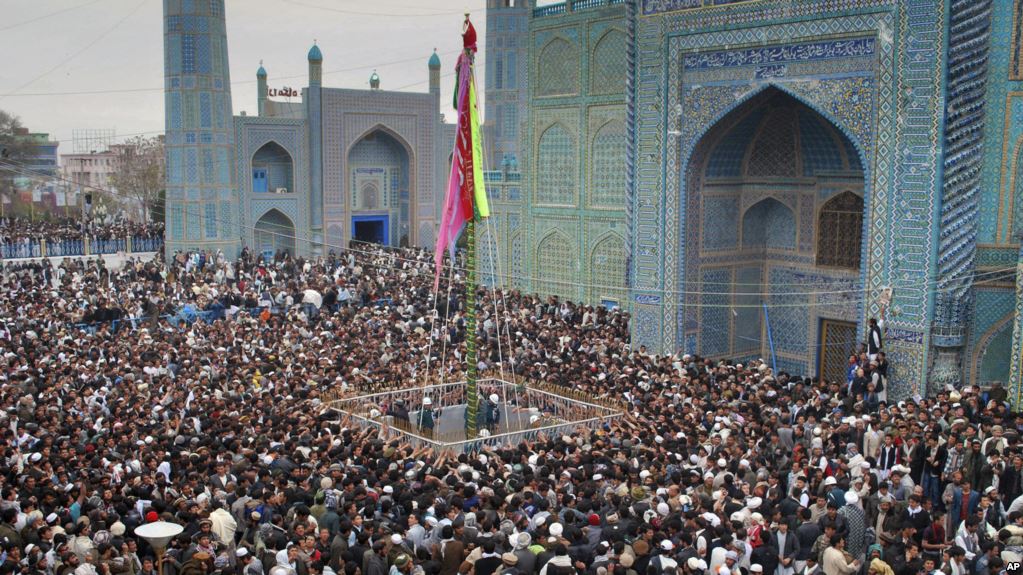 Afghans cheer after rising the a colorful banner at the shrine of Imam Ali during  celebrations of the Afghan New Year at the Imam Ali's shrine in Mazar-I-Sharif, Balkh province north of Kabul, Afghanistan on Sunday, March 21, 2010. Afghanistan's hard-line vice president expressed hope Sunday that an upcoming national conference will lay the foundation for peace with insurgents as a dozen civilians died in separate bombings in front-line provinces. (AP Photo/Mustafa Najafizada)