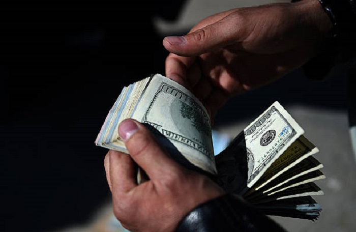 An Afghan money changer counts US dollars at the currency exchange Sarayee Shahzada market in Kabul on December 17, 2015.  The Afghani exchange rate is one US dollar equal to 68.40 Afghani which is set by the Central Bank of Afghanistan.  AFP PHOTO / Wakil Kohsar / AFP / WAKIL KOHSAR        (Photo credit should read WAKIL KOHSAR/AFP/Getty Images)