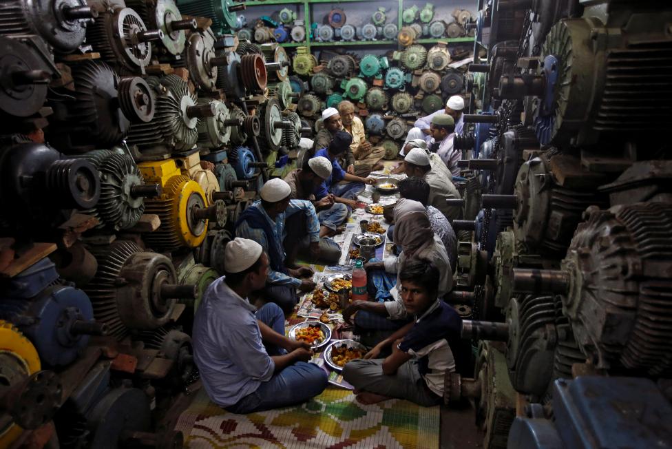 Muslims eat their iftar (breaking of fast) meal at a water pump workshop in the old quarters of Delhi, June 8, 2016. REUTERS/Adnan Abidi