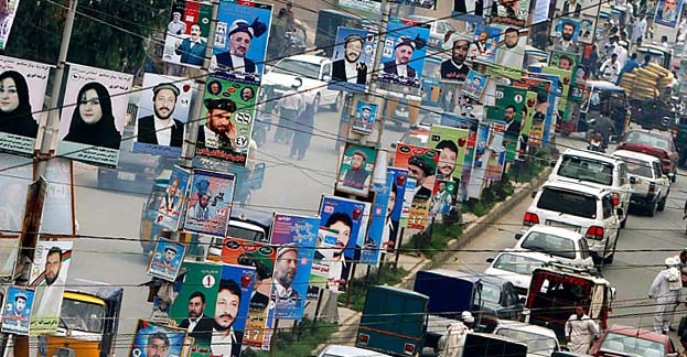 Election posters line a street in Jalalabad, east of Kabul, Afghanistan, on Monday, Aug. 16, 2010. Afghans will go to the polls for parliamentary elections in September. (AP Photo/Rahmat Gul)