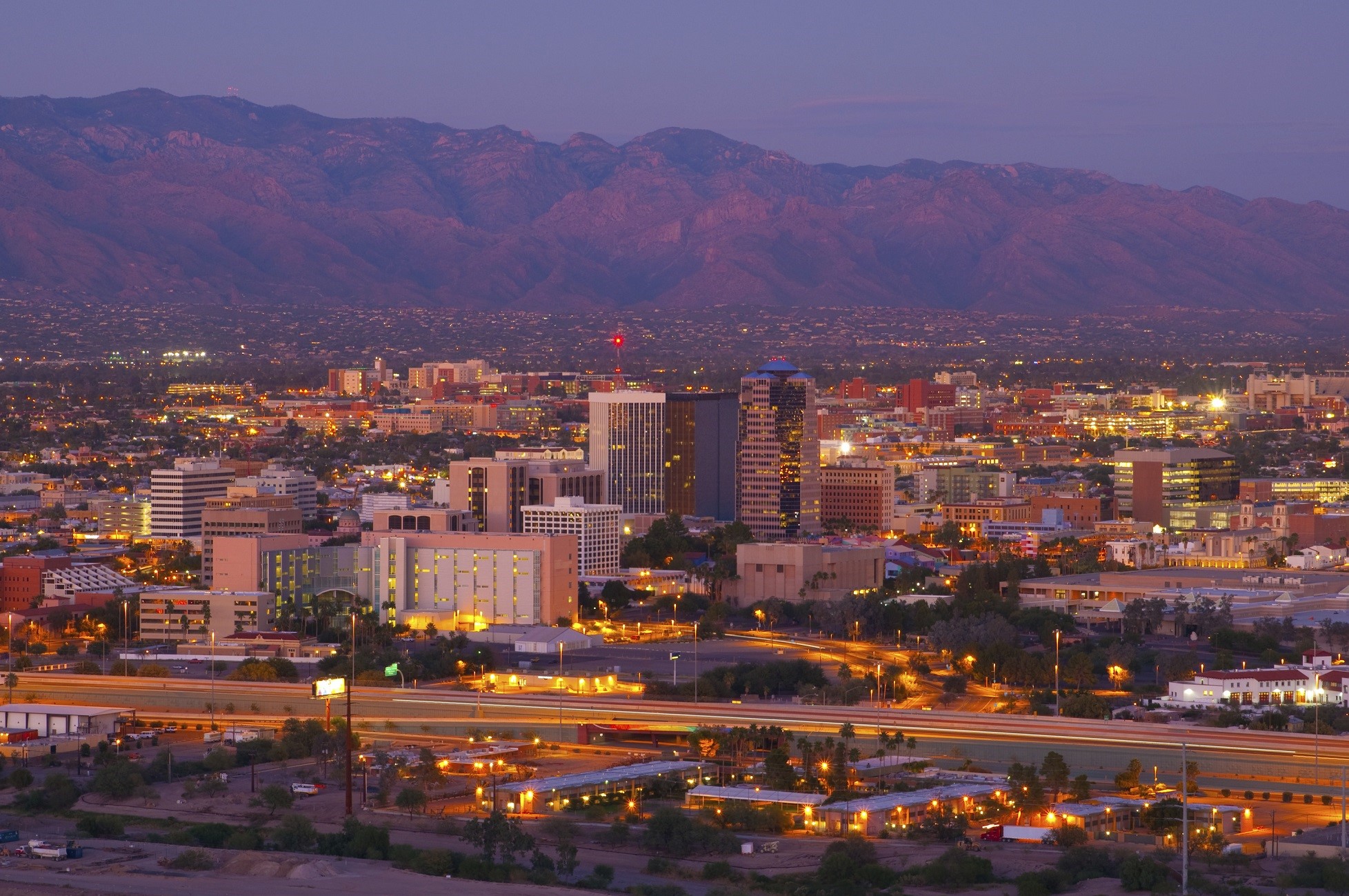 Tucson downtown skyline and aerial overview (including the University of Arizona) w/ Catalina Mountains at dusk.